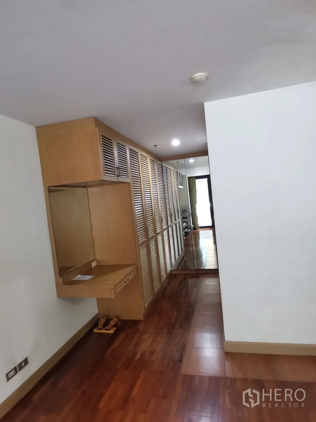 公寓 出租在Pathum Wan, Bangkok - 走廊设整排百叶嵌入式衣柜与梳妆台，铺木地板。