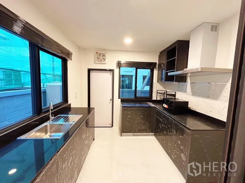 บ้าน ให้เช่าในBang Phli, Samut Prakan - ห้องครัวบิวท์อิน เคาน์เตอร์หินสีดำ ตู้เก็บของ เครื่องดูดควัน และหน้าต่างบานใหญ่