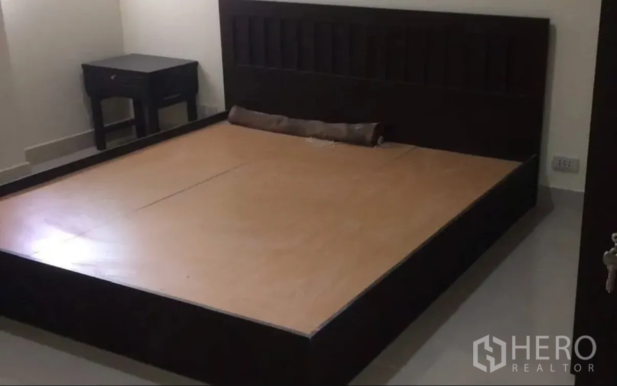 คอนโด for sale in Watthana, Bangkok - ห้องนอนพร้อมเตียงไม้สีเข้มและโต๊ะข้างเตียง