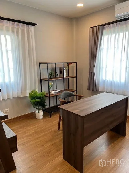 独立式住宅 出租在Bang Phli, Samut Prakan - 书房，木质书桌、开放式置物架与转角窗采光。