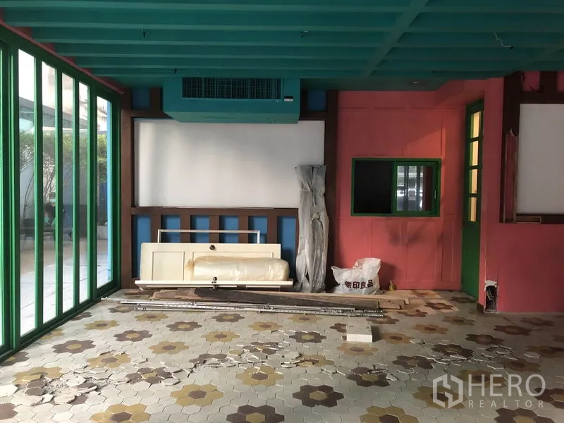Retail Space for rent in Khlong Toei, Bangkok - Street-facing retail space with folding green glass panels, patterned tiles and ceiling AC unit.