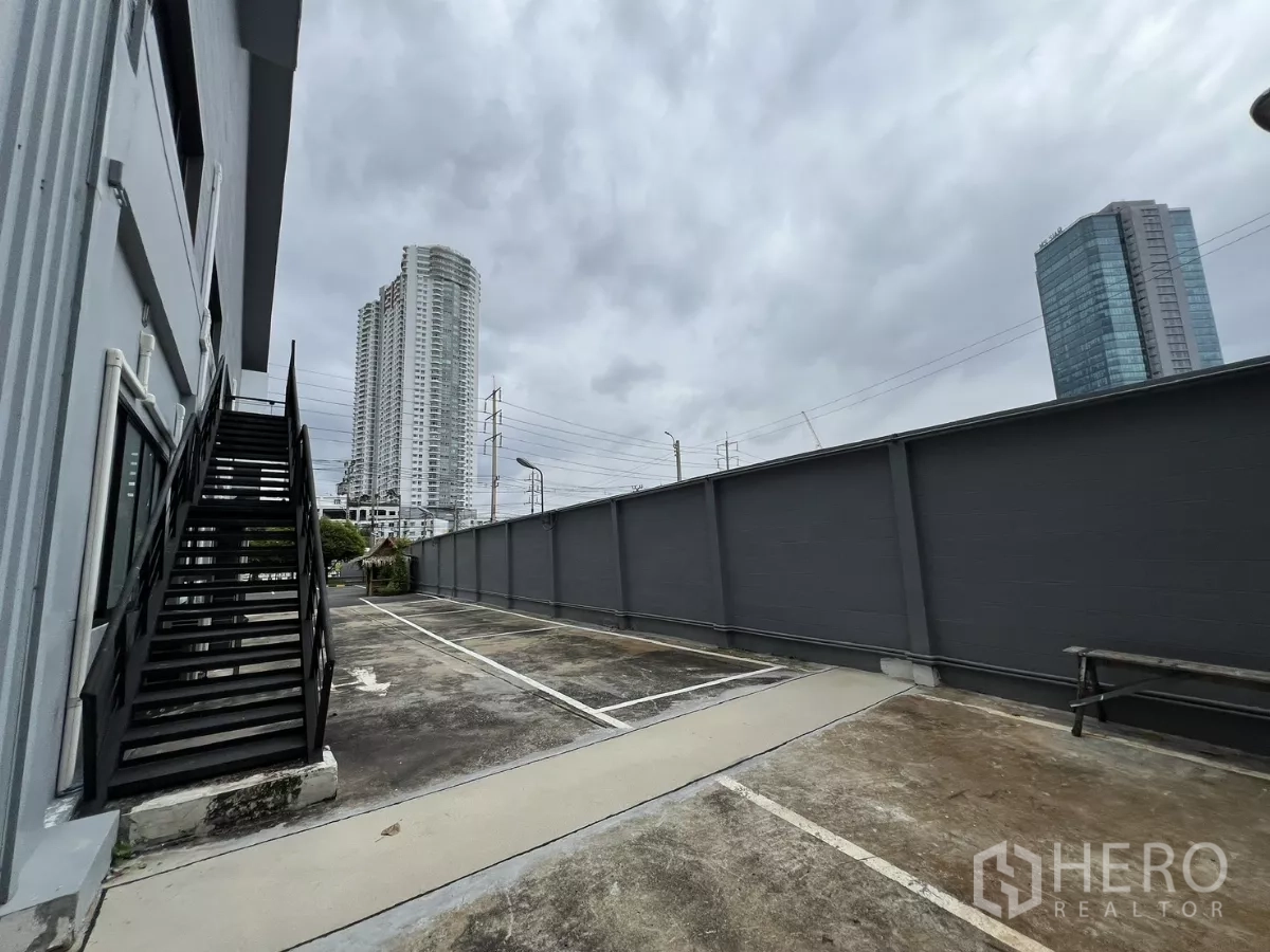 Warehouse for rent in Yan Nawa, Bangkok - Private parking bays and an exterior staircase with Bangkok high-rises in the background.
