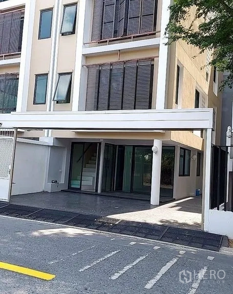 带办公室的家 出租在Huai Khwang, Bangkok - 一层带顶停车位与玻璃入口，配木质百叶遮阳的细节特写。