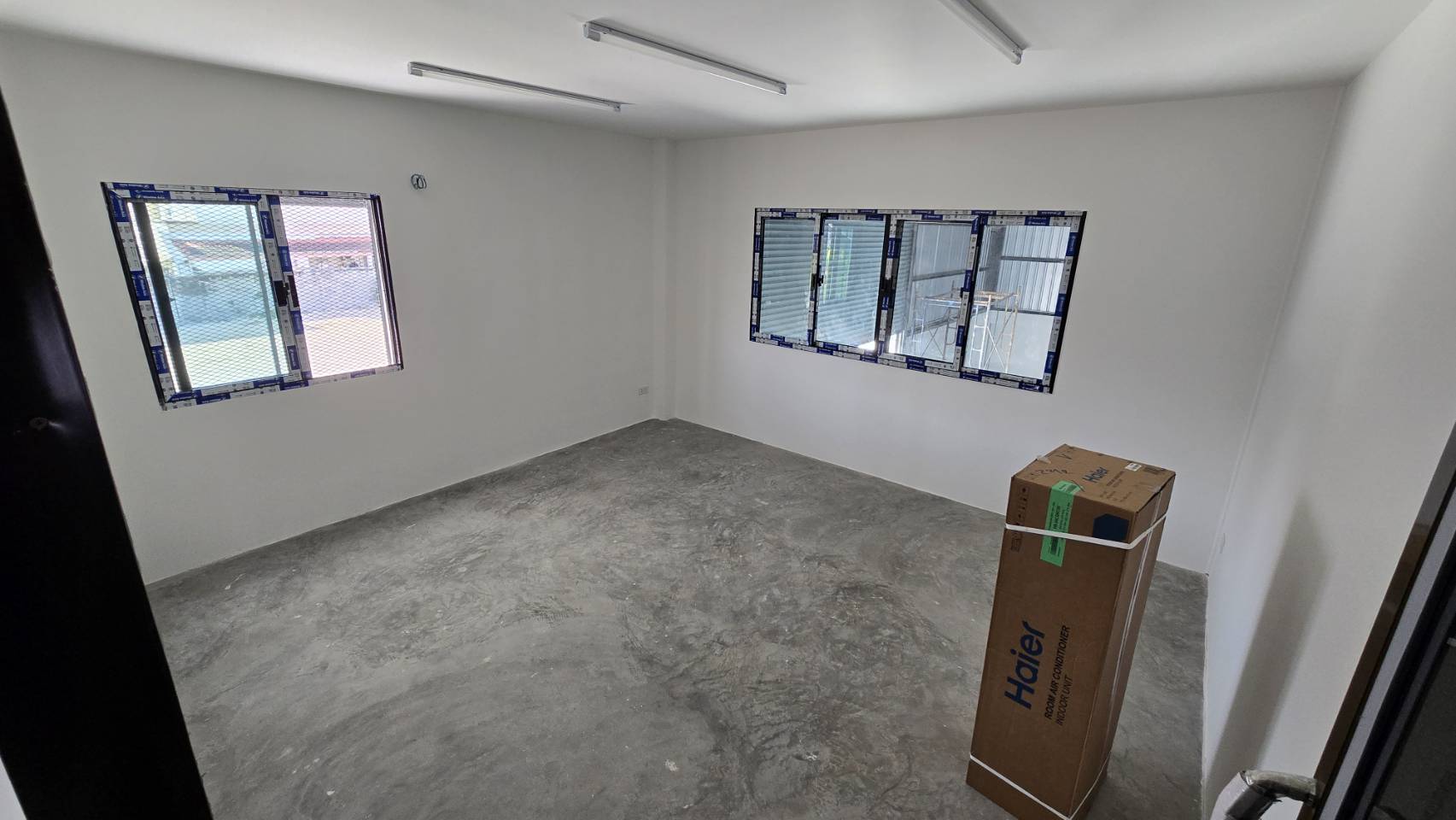 คลังสินค้า for rent in Bang Phli, Samut Prakan - ห้องออฟฟิศสว่าง ผนังสีขาว หน้าต่างหลายบาน และพื้นคอนกรีตดิบภายในโกดัง