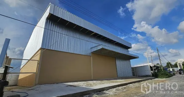 Warehouse for rent in Lat Krabang, Bangkok - Street view of a modern metal-clad warehouse with wide loading apron and canopy.