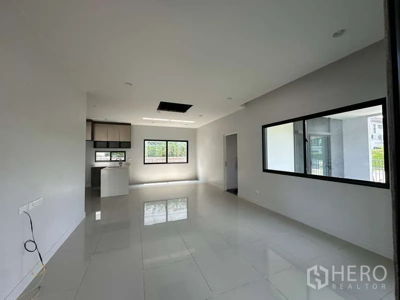 Detached House for sale in Lam Luk Ka, Pathum Thani - Open living space with glossy tiles and large windows.