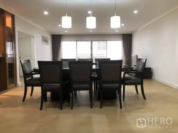 Condominium for rent in Watthana, Bangkok - Large dining space seating ten beneath trio pendant lights with wide window for natural light.