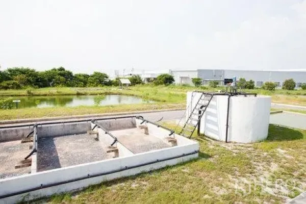 工厂 出租在Chachoengsao - 沉淀池与混凝土处理槽，旁有绿化的工业用地景观。