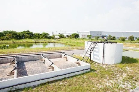 工厂 出租在Chachoengsao - 沉淀池与混凝土处理槽，旁有绿化的工业用地景观。