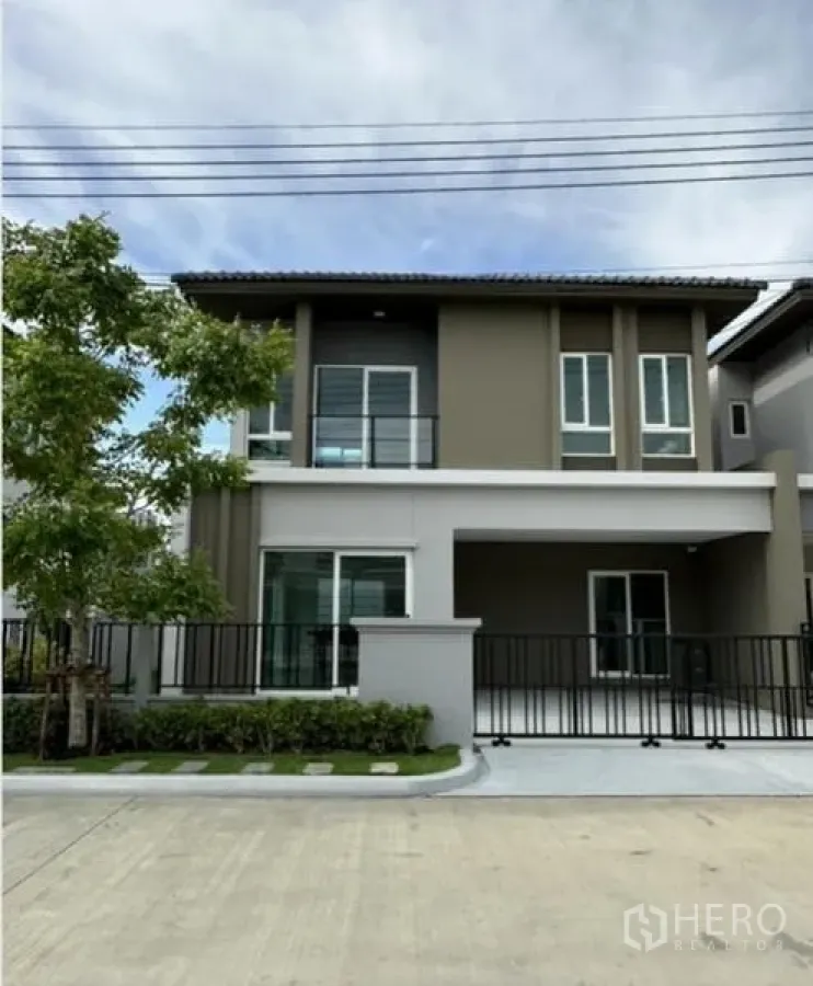 ทาวน์เฮาส์ ให้เช่าในBang Phli, Samut Prakan - ด้านหน้าทาวน์เฮ้าส์พร้อมทางจอดรถ รั้ว และพื้นที่สีเขียว