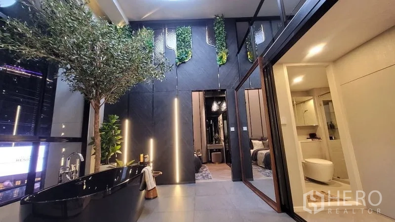 独立式住宅 出售在Watthana, Bangkok - 室内庭院设黑色独立浴缸、垂直绿植墙，旁接卧室与浴室