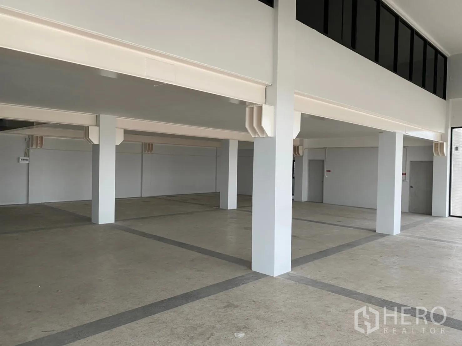 Warehouse for rent in Lat Krabang, Bangkok - Spacious ground-floor storage area with structural columns and polished concrete floor.