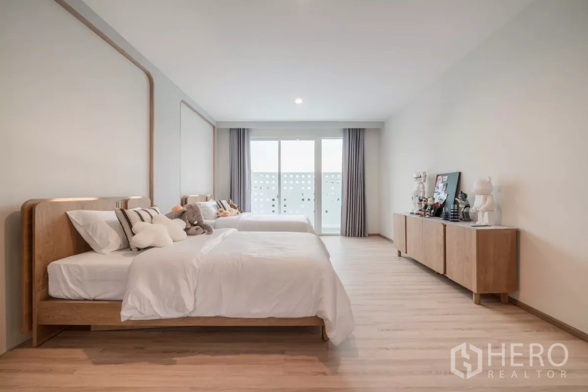 Detached House for rent in Saphan Sung, Bangkok - Extra‑large twin bedroom with two beds, sideboard and balcony doors.