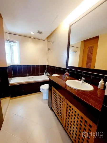 Apartment for rent - Bathroom with bathtub, shower over tub, single basin and dark tile accents.