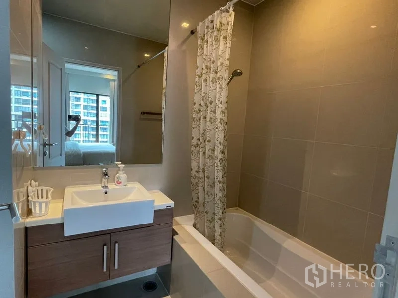 Condominium for rent in Bangkok - Bathroom with vanity sink, storage cabinet and a shower-over-bathtub.