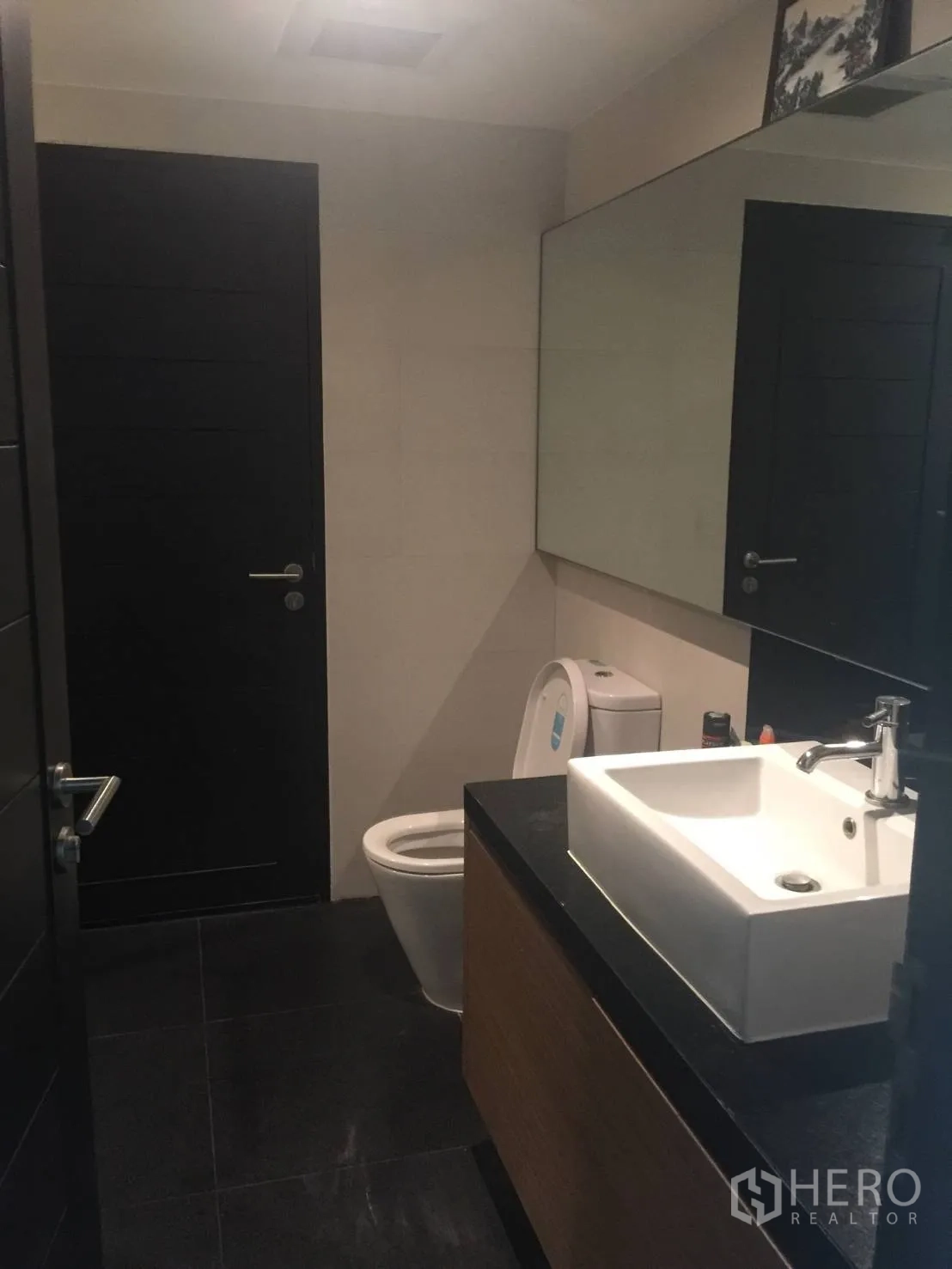 Condominium for rent in Watthana, Bangkok - Secondary bedroom with built-in wooden wardrobe and upholstered headboard.