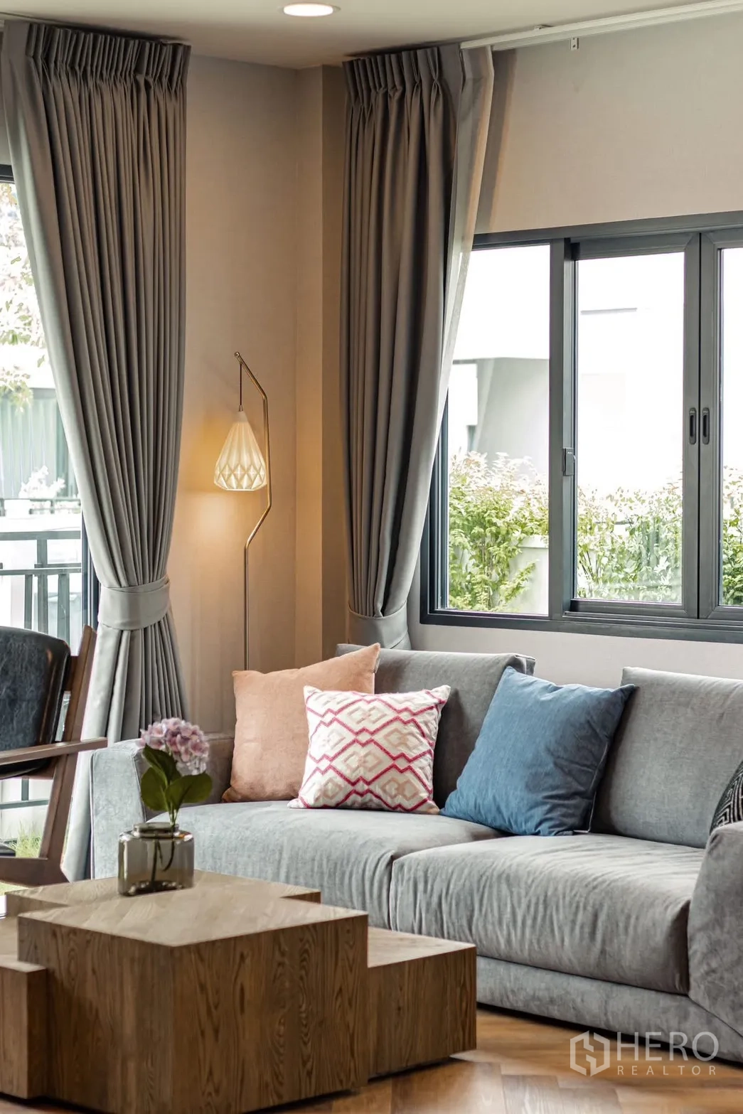 独栋房屋 for rent in Bang Phli, Samut Prakan - 明亮客厅，灰色沙发、落地灯、木质茶几与大窗帘。