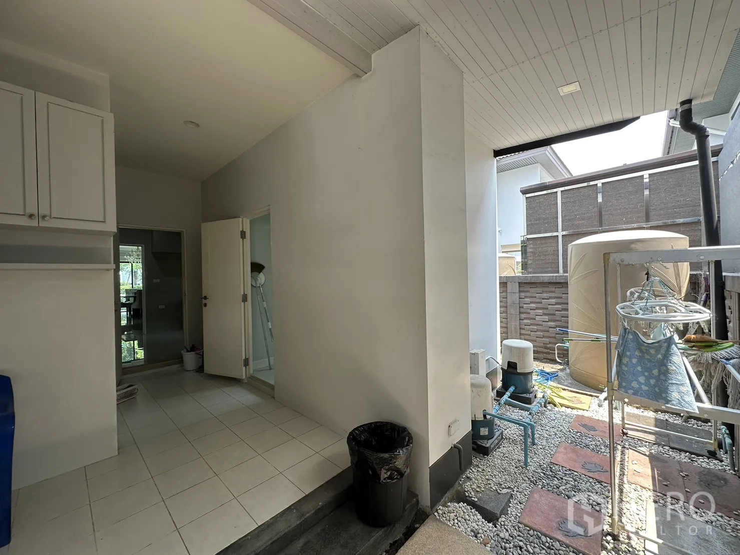 Detached House for rent or sale in Lam Luk Ka, Pathum Thani - Covered utility and laundry area with water tank and equipment.