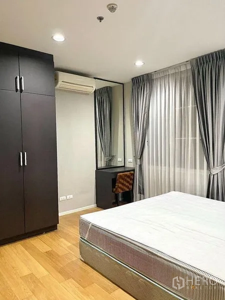 公寓 出租在Watthana, Bangkok - 卧室配衣柜、镜面梳妆台、空调与大窗帘。