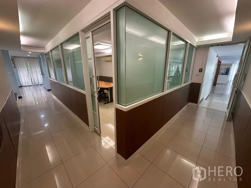 Office Space for sale - Hallway with frosted glass partitions leading to multiple offices.