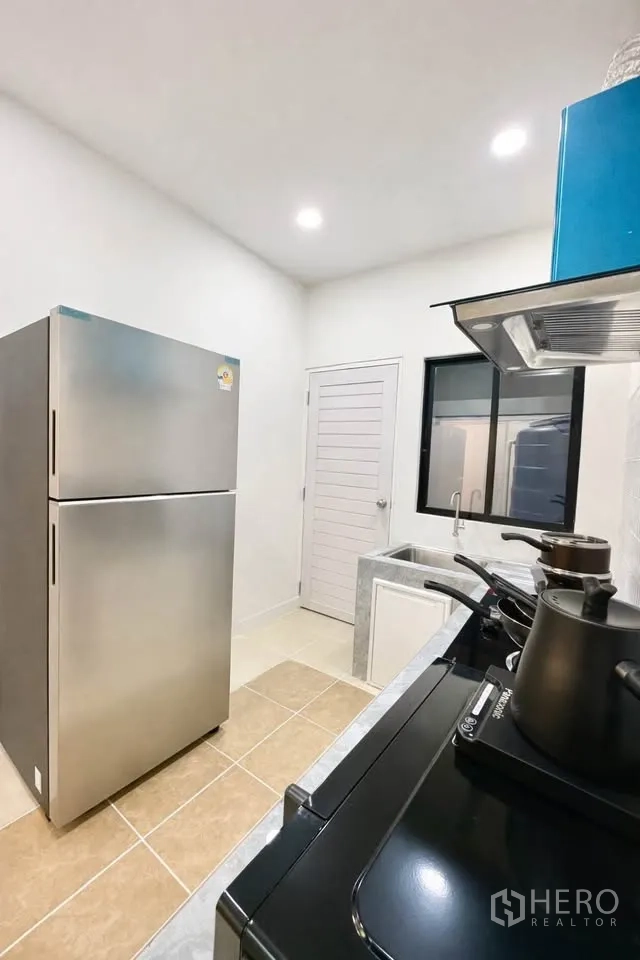บ้านเดี่ยว for rent in Huai Khwang, Bangkok - อีกมุมของครัวเห็นตู้เย็น ซิงก์ติดหน้าต่าง และเตา