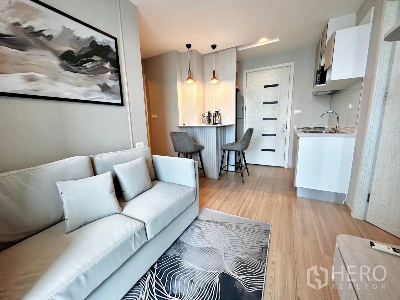 公寓 for rent in Suan Luang, Bangkok - 起居室近景，展示沙发、小厨房与双吧椅的吧台。