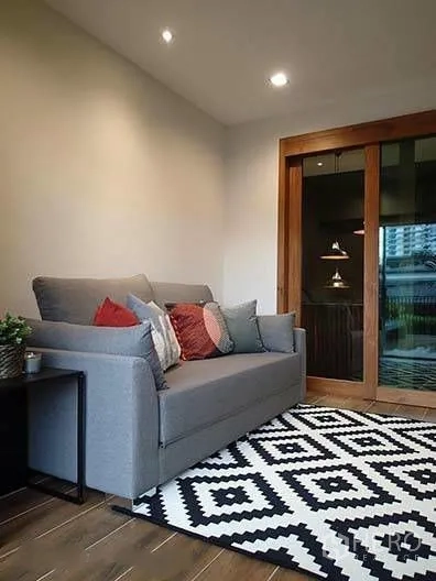 ทาวน์เฮาส์ for rent in Watthana, Bangkok - ห้องนั่งเล่นขนาดกะทัดรัด โซฟาสีเทาและพรมลายข้างประตูบานเลื่อนไม้
