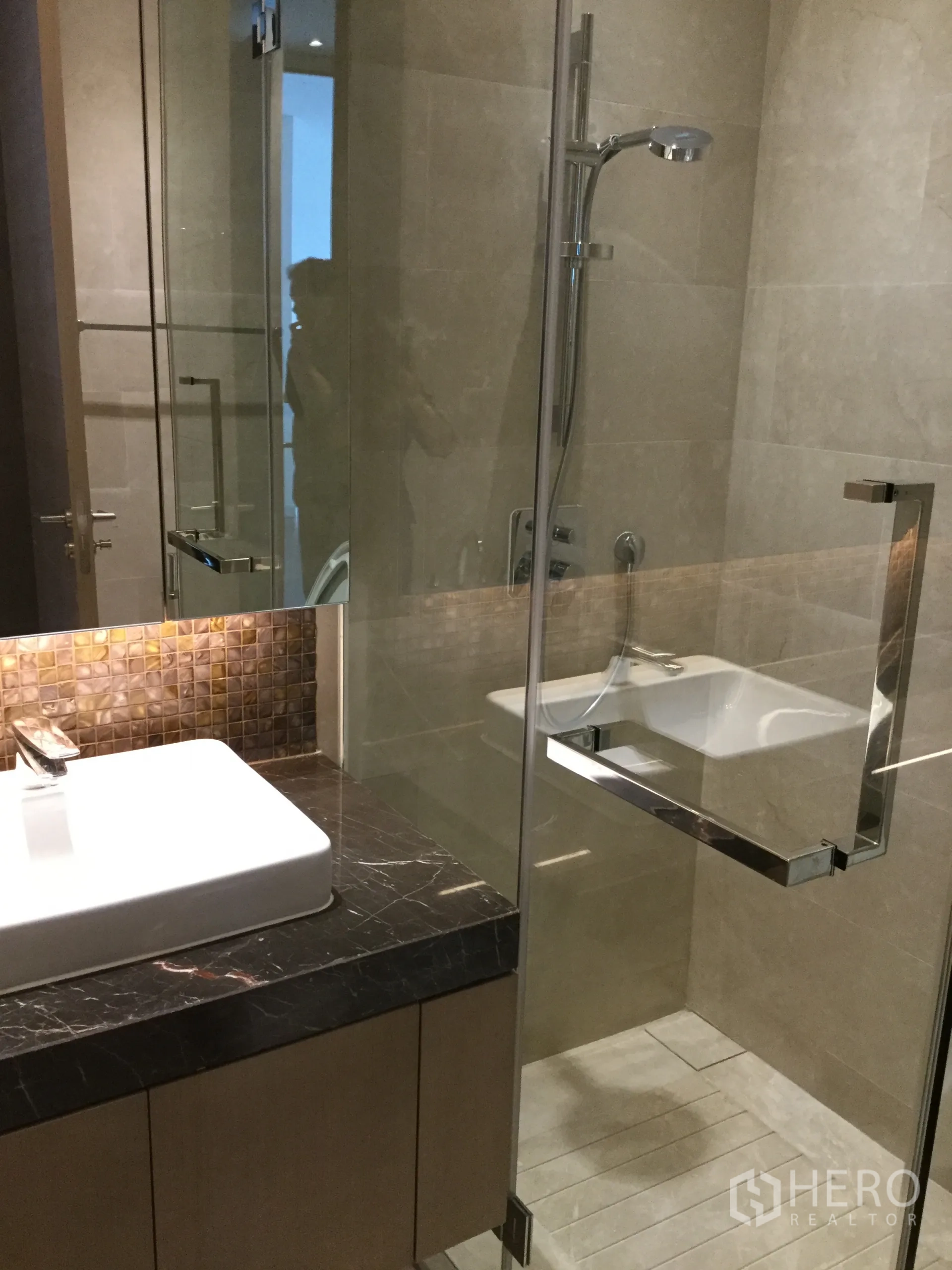 公寓 出租在Pathum Wan, Bangkok - 酒店风浴室，玻璃淋浴房、方形台盆与深色大理石台面。