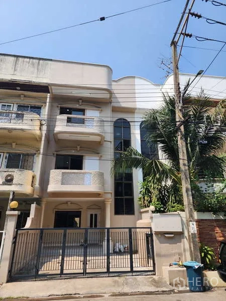 联排别墅 出租在Wang Thonglang, Bangkok - 房屋正面与前院铁门的街景。