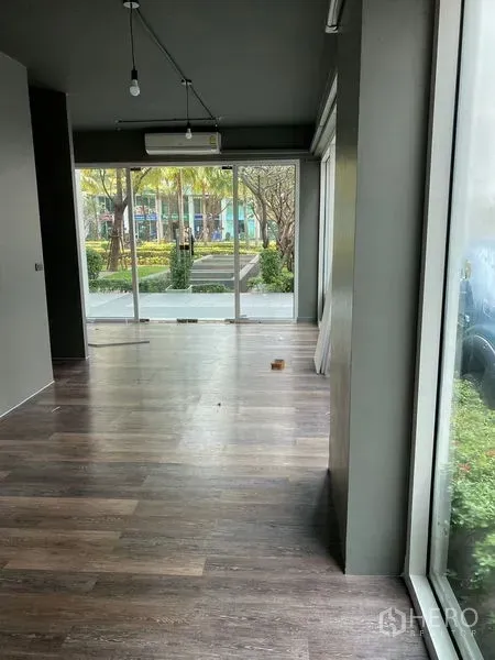 Retail Space for rent in Huai Khwang, Bangkok - Open retail area with wood floors, large windows and views of a landscaped walkway.