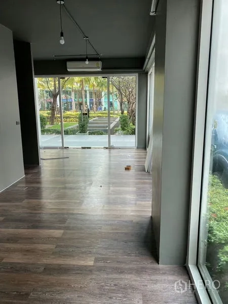 Retail Space for rent in Huai Khwang, Bangkok - Open retail area with wood floors, large windows and views of a landscaped walkway.