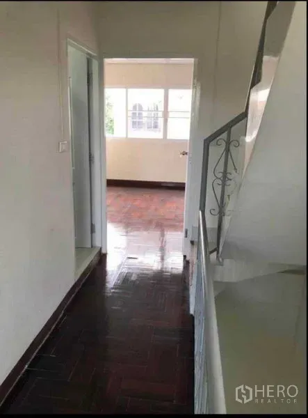 带办公室的家 出租或出售在Watthana, Bangkok - 楼上走廊，深色拼花地板与白墙，尽头为采光充足的房间。
