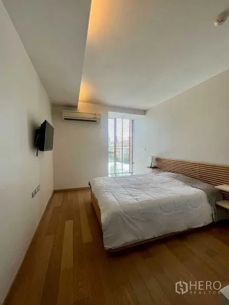 公寓 出租或出售在Watthana, Bangkok - 极简卧室，墙挂电视、空调与大窗户。