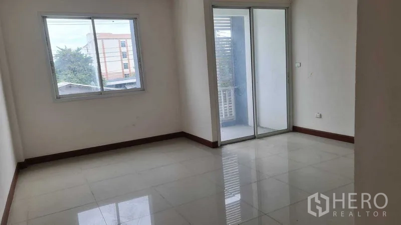 Townhouse for  in Lam Luk Ka, Pathum Thani - Spacious bedroom with two windows and a sliding door to the balcony.