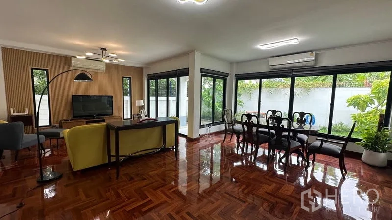 独立式住宅 出租在Watthana, Bangkok - 开放式客餐厅，大面积窗户与木地板。