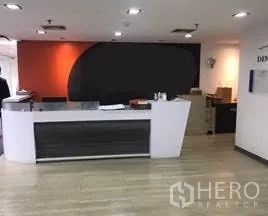 Office Space for rent in Khlong Toei, Bangkok - Modern reception area featuring a white front desk and an orange accent wall.