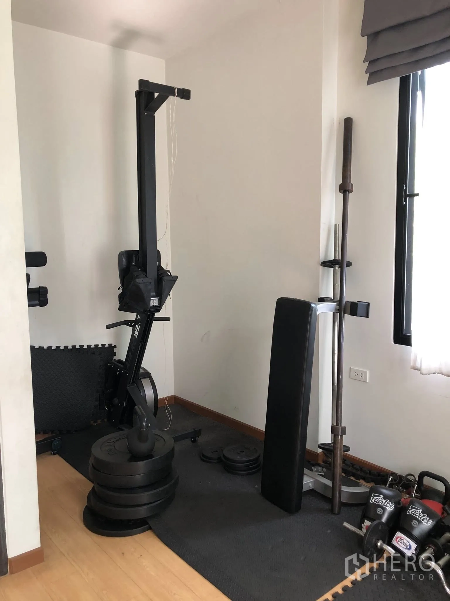 Townhouse for sale in Phra Khanong, Bangkok - Compact home gym corner featuring a rowing machine and free weights.