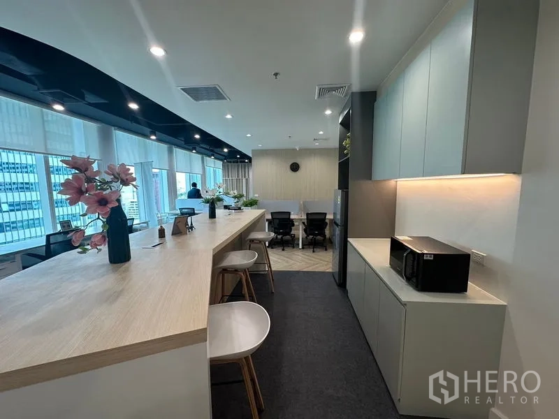 Office Space for rent - Pantry counter and storage cabinets with microwave overlooking workspace.