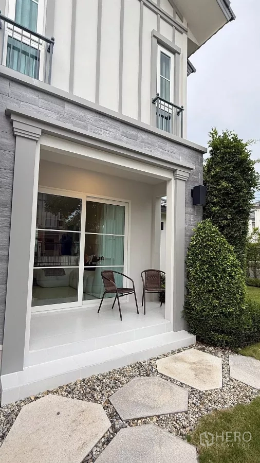 Detached House for rent in Bang Phli, Samut Prakan - Small front porch with two chairs and a stepping-stone path beside landscaped shrubs.