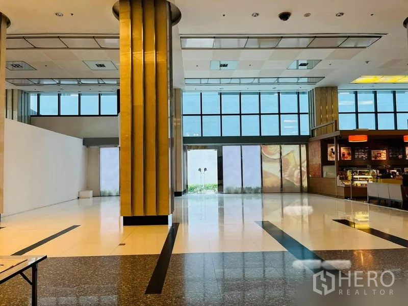 零售空间 出租在Khlong Toei, Bangkok - 临近玻璃出入口的铺面立面，高窗采光良好，旁设咖啡店