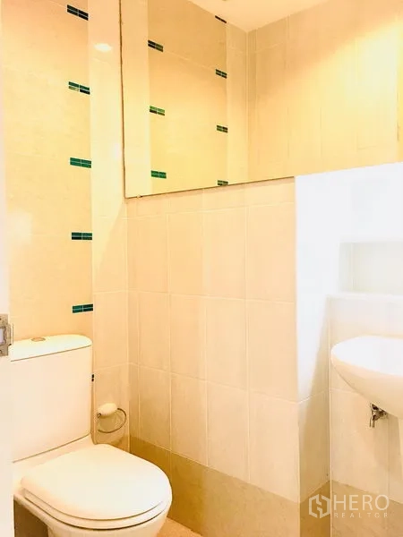 联排别墅 出租在Prawet, Bangkok - 小巧浴室，坐便器、台盆与大镜子，浅色瓷砖铺设。