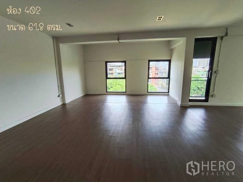 办公空间 出租在Phaya Thai, Bangkok - 宽阔房间配三扇横向窗，可见树梢与城市景致。