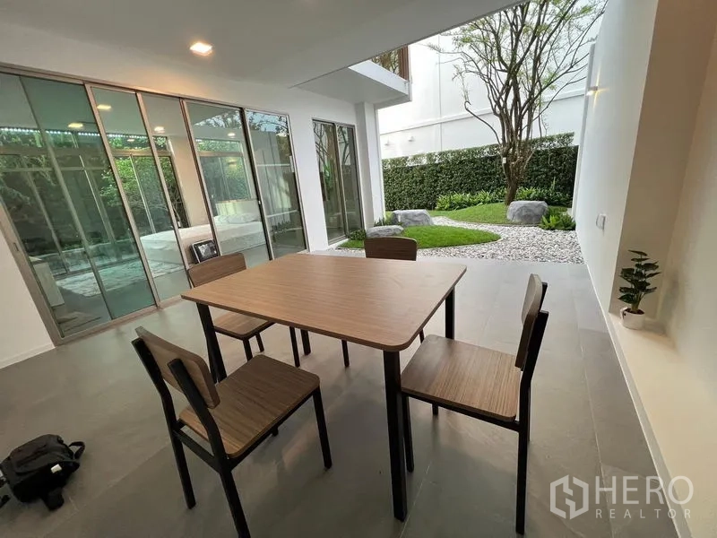 Detached House for rent - Covered dining patio beside sliding glass doors and a landscaped courtyard garden with stones.