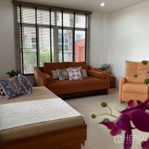 Detached House for rent in Lat Krabang, Bangkok - Family room with large windows, orange sofa and lounge chair.