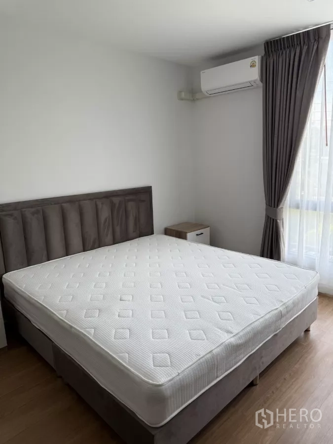 Townhouse for rent or sale in Bang Phli, Samut Prakan - Primary bedroom with king bed, curtains and air-conditioning.