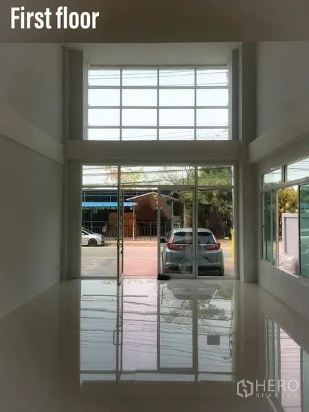 带办公室的家 出租在Min Buri, Bangkok - 一层挑高大厅，整面落地玻璃与亮面地砖，面向街道。