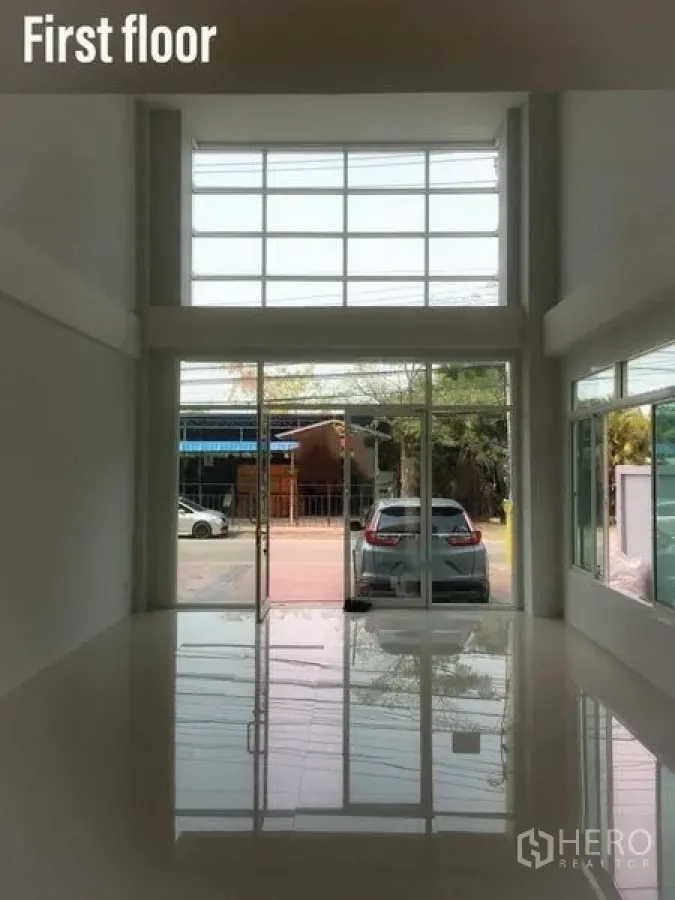 带办公室的家 出租在Min Buri, Bangkok - 一层挑高大厅，整面落地玻璃与亮面地砖，面向街道。