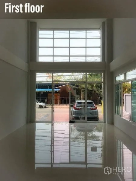 带办公室的家 出租在Min Buri, Bangkok - 一层挑高大厅，整面落地玻璃与亮面地砖，面向街道。
