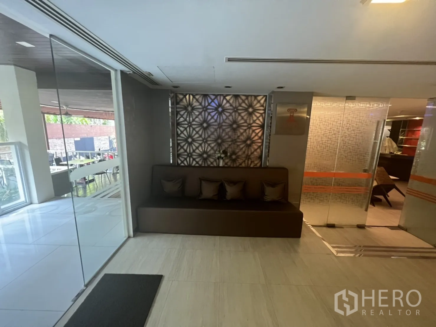 零售空间 出租在Khlong Toei, Bangkok - 接待休息角，内嵌式长椅、抱枕与通往露台的玻璃隔断。