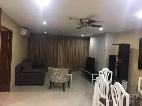 Condominium for rent in Watthana, Bangkok - Lounge with ceiling fan, media unit and floor-to-ceiling drapes.
